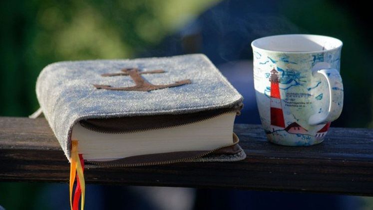 eine aufgeschlagene Bibel auf einem Stein